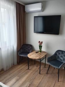salon ze stołem, 2 krzesłami i telewizorem w obiekcie Pensjonat Mickiewicz w mieście Sandomierz