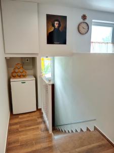 a kitchen with a staircase with a refrigerator and a clock at Pensjonat Mickiewicz in Sandomierz