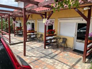 a patio with tables and chairs under a pergola at Gábor Magánszállás Nagykanizsa Alkotmány út 195 in Palin