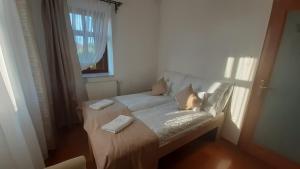 a white couch in a room with a window at Bíbic Apartman C in Kápolnásnyék