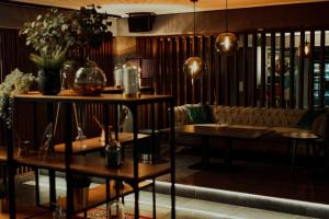 a restaurant with a couch and tables and flowers at Hotel Alibaba in Humenné