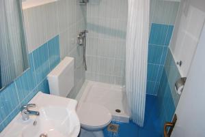W łazience znajduje się umywalka, toaleta i prysznic. w obiekcie Apartment LAGUNA 64 w mieście Izola