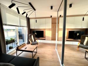 a living room with a couch and chairs and a table at Apartament Fredry 2 PREMIUM KLIMA in Kołobrzeg