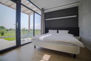 a bedroom with a large bed and a large window at Bungalows Kingsland in Ineu +3 photos