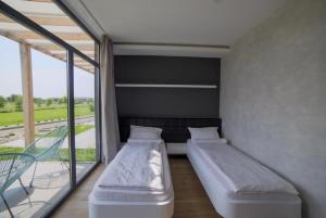 a room with two beds and a large window at Bungalows Kingsland in Ineu