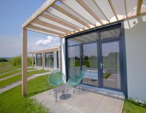 two chairs and a table on a patio at Bungalows Kingsland in Ineu