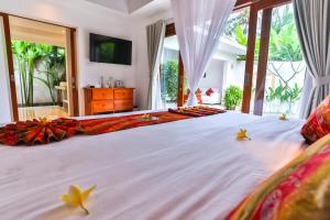 a bedroom with a large bed with flowers on it at Jivana Resort in Kuta Lombok +99 photos
