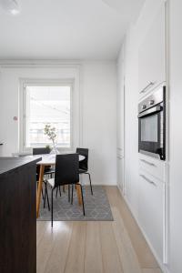 a kitchen with a table and chairs and a refrigerator at 2ndhomes Tampere "Penthouse" Apartment - Private Sauna & Terrace in Tampere