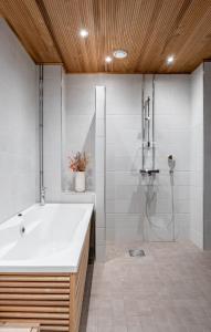 a bathroom with a white tub and a shower at 2ndhomes Tampere "Penthouse" Apartment - Private Sauna & Terrace in Tampere