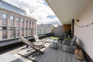 a balcony with benches and chairs on a building at 1BR Penthouse with Sauna & Rooftop Terrace in Tampere