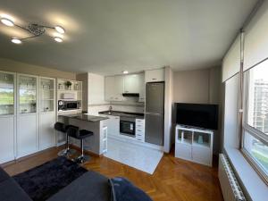 eine große Küche mit weißen Schränken und einer Couch in einem Zimmer in der Unterkunft housingcoruña ROSALES in A Coruña