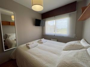 ein Schlafzimmer mit einem großen Bett und einem Spiegel in der Unterkunft housingcoruña ROSALES in A Coruña