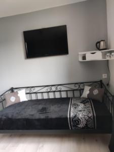 een slaapkamer met een bed en een flatscreen-tv bij Les chambres d'hôtes du port de loguivy de la mer in Ploubazlanec