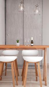 - une table en bois avec 2 chaises blanches et une bouteille de vin dans l'établissement The Mini Beach Hotel, à Stalós