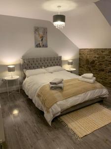 ein Schlafzimmer mit einem großen Bett mit zwei Tischen und zwei Lampen in der Unterkunft No. 22 in Derry Londonderry