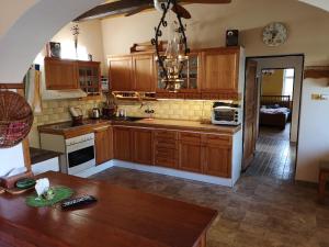 a kitchen with wooden cabinets and a wooden table at Country house Horné Držkovce in Horné Držkovce