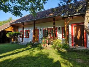 a house with red and white doors and a yard at Country house Horné Držkovce in Horné Držkovce