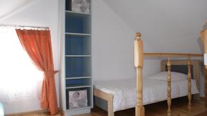a bedroom with a bed and a book shelf at Domek pod różą in Krasnobród