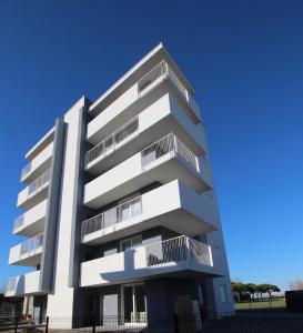 een wit appartementencomplex met balkons bij Gray Palace - Home Immobiliare Jesolo in Lido di Jesolo