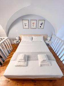 Un dormitorio con una cama con sábanas y almohadas blancas. en Nice House San Biagio - Luxury Full Apartment, en Lecce