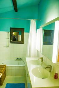 a bathroom with two sinks and a tub and a mirror at Le Jardin des Copains in Canet