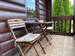 una mesa de madera y 2 sillas en el porche en Wooden House, en Podgorica
