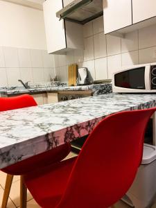 een keuken met rode stoelen en een marmeren aanrecht bij Depto 4 Metro Cal y Canto 1 dormitorio y 1baño in Santiago