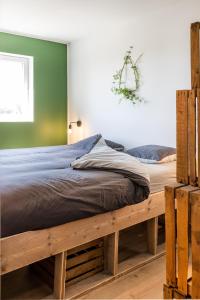 a bed with a wooden frame in a bedroom at Vakantieverblijf De Backstage in Heuvelland