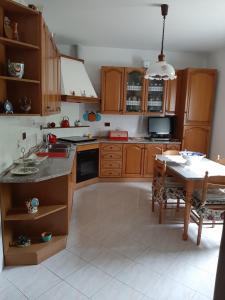 una cocina con armarios de madera y una mesa. en B&B CA'di Beppe en Madonna di Fornelli