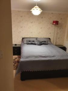 a bedroom with a large bed with a light on it at Beautiful ensuite room in Wellingborough