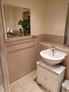 a bathroom with a sink and a mirror at Beautiful ensuite room in Wellingborough