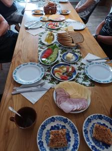 une table en bois avec des assiettes de nourriture dans l'établissement Base Camp Carpathia, à Wrocanka