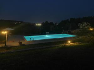 una piscina por la noche con luz en Al Palmento Cruillas, en Siracusa