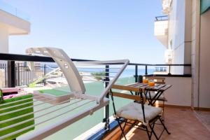 ヴロラにあるBay Inn Apartment Sea Frontの建物の上にテーブルと椅子が置かれたバルコニー
