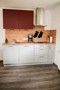 a kitchen with white cabinets and a sink at Ferienwohnungen Finkengrund in Büren