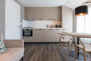 a kitchen and living room with a table and a couch at Centrum-Appartementen Langstraat 5 in Zoutelande