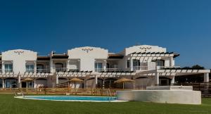 un gran edificio blanco con una piscina frente a él en Gran Villa Roquetas Beach & Golf Playa Serena, en Roquetas de Mar