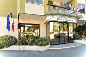 a hotel entrance with flags in front of a building at Hotel Diano Marina Mhotelsgroup in Diano Marina