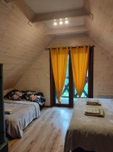 a attic bedroom with two beds and a window at Wdzydzka Chatka in Wdzydze Tucholskie