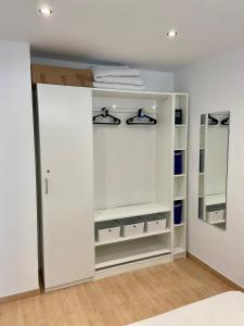 a closet with white cabinets and a mirror at Appartment Yumbo Playa del Ingles in Playa del Ingles