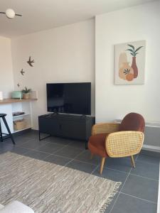 - un salon avec une télévision à écran plat et une chaise dans l'établissement Cannes, appartement avec parking+terrasse, Croisette à pied!, à Cannes