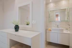 W białej łazience znajduje się umywalka i lustro. w obiekcie Valentino Luxury Villa w mieście Planos