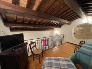 a living room with a television and a balcony at Agriturismo Antico Castagno in Montebibico