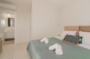 um quarto com uma cama com chinelos brancos em Valentino Luxury Villa em Plános