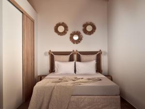 a bedroom with a bed with two mirrors on the wall at Margie Sea View Apartment in Zakynthos