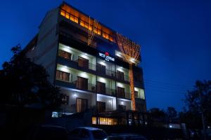 een hoog gebouw met 's nachts verlichting bij West Lerruat Hotel in Nairobi