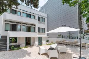 an external view of a building with chairs and an umbrella at BE BOLD HOSTEL in Antalya