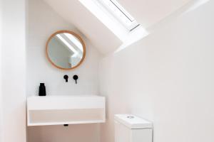 ein Badezimmer mit einem weißen Waschbecken und einem Spiegel in der Unterkunft St Ives House Lowenek in St Ives