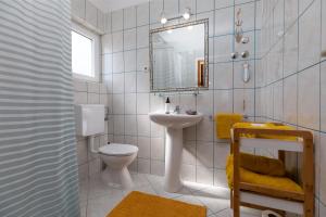 a bathroom with a sink and a toilet and a mirror at Apartments Paloc - Yellow in Bol