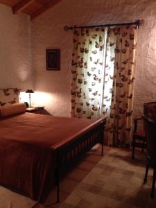 una camera da letto con un letto e una finestra con tende di Moinho do Comandante a Faial
